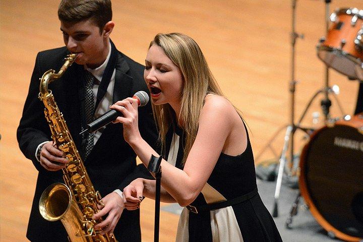 Female student singing into microphone